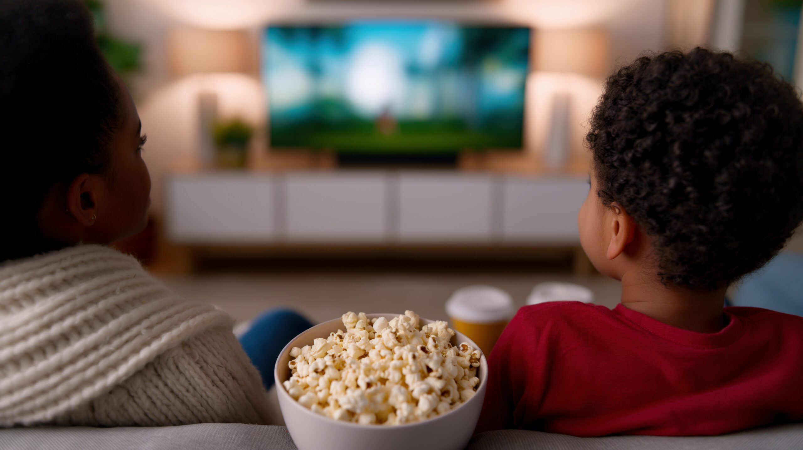 Child enjoying a cozy Friday family movie night with popcorn at home